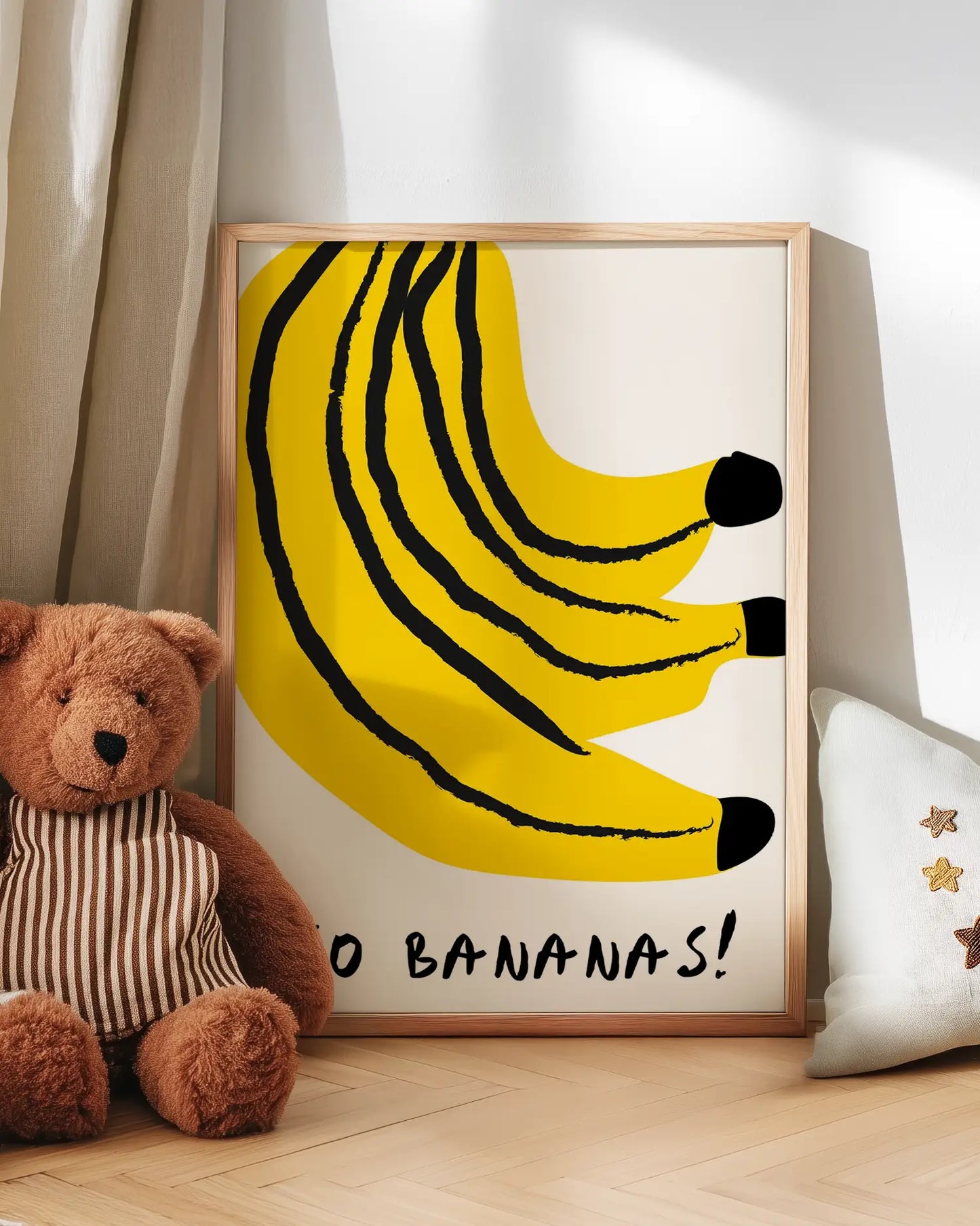 Artwork of bananas with 'Go Bananas!' text, teddy bear, and pillow in a room setting.