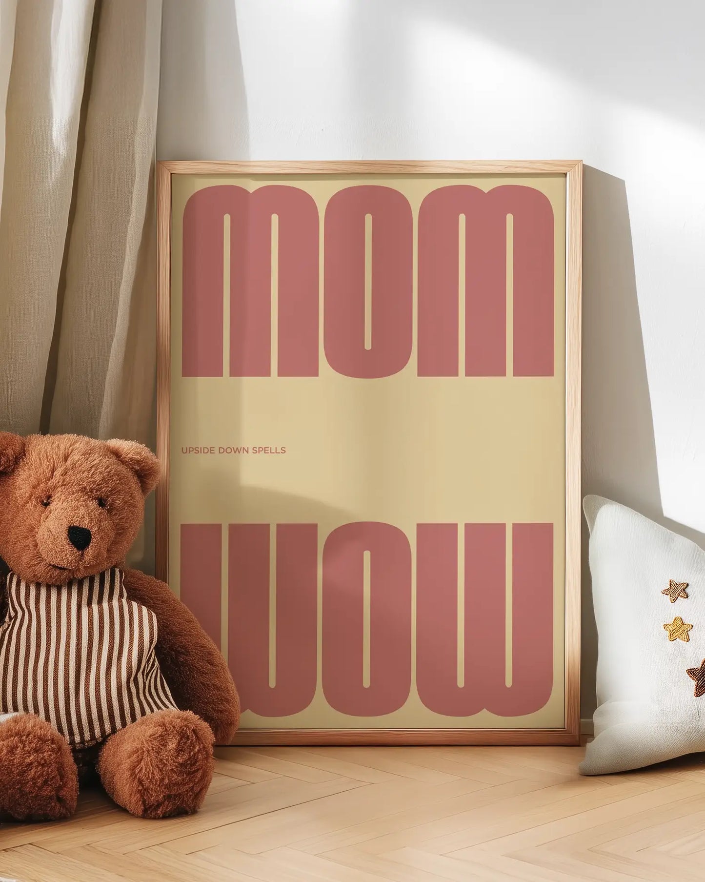 Artwork with 'MOM upside down spells WOW' in pink text next to a teddy bear on a wooden floor.