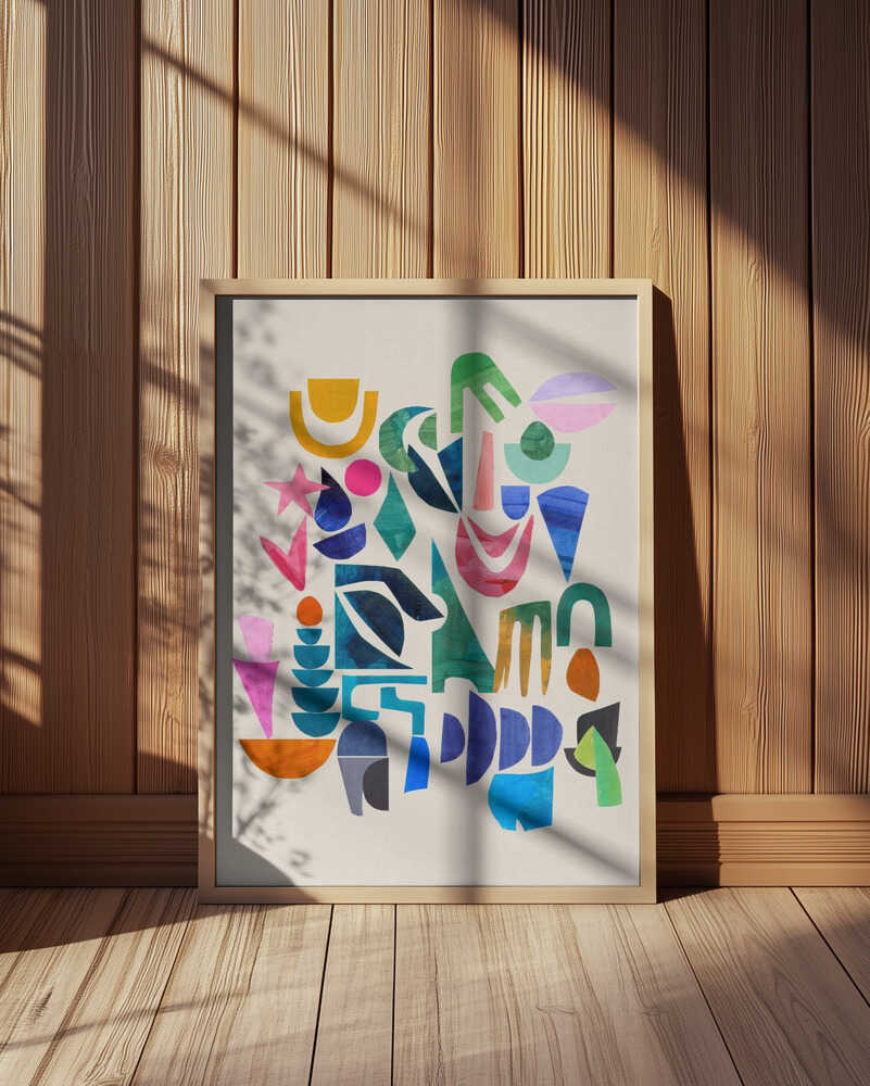 Colorful abstract art print featuring bold geometric shapes in blue, green, pink, yellow, and orange on a white background. Displayed in a light wooden frame leaning against a wooden wall with soft natural sunlight and shadows. Modern wall art perfect for creative Scandinavian interiors.