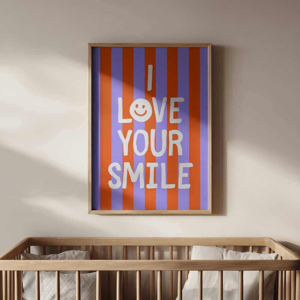 Framed poster with the text 'I love your smile' on a striped background, hanging above the baby crib.
