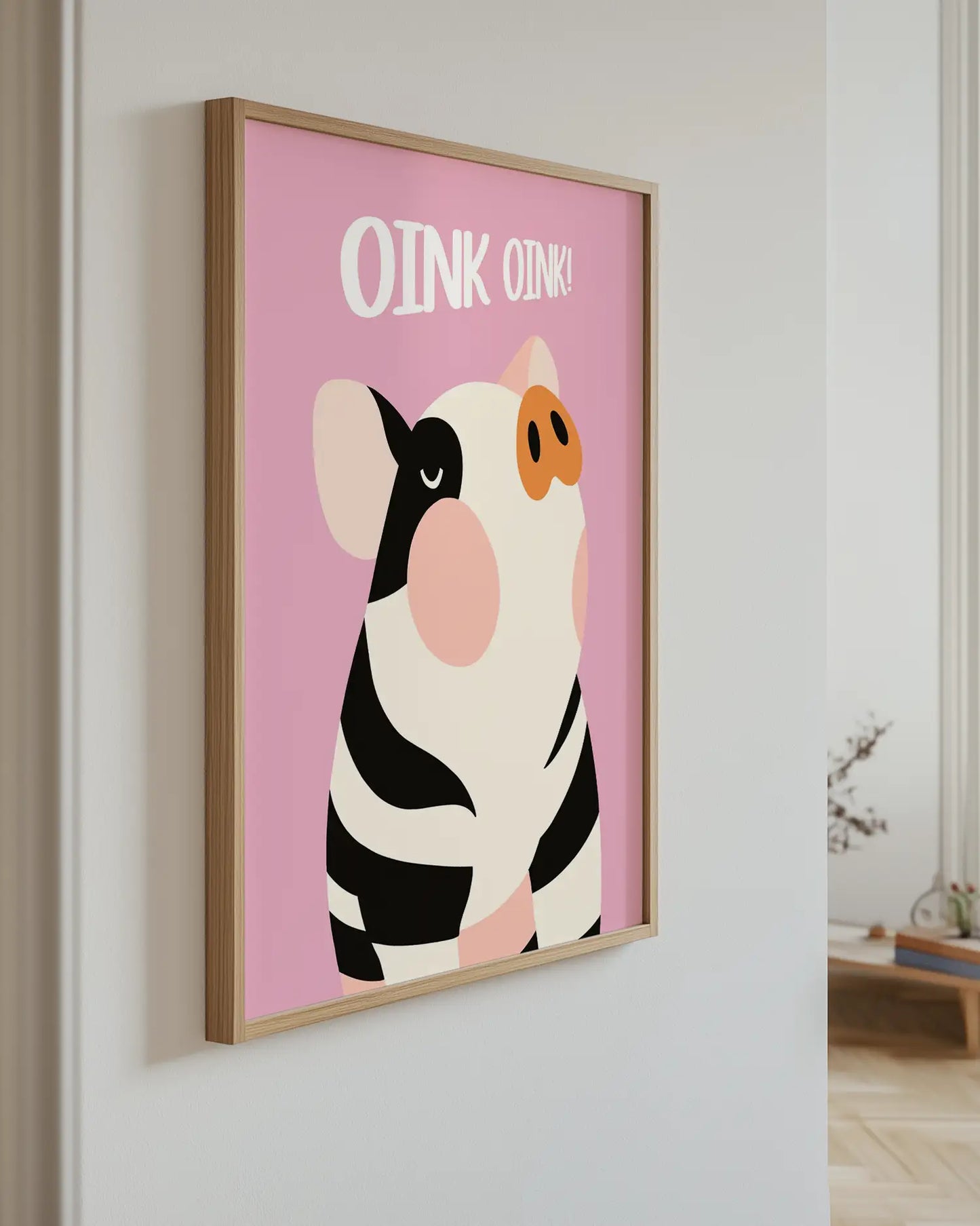 Poster of a cartoon cow with 'OINK OINK' text on a pink background, mounted on a wall.