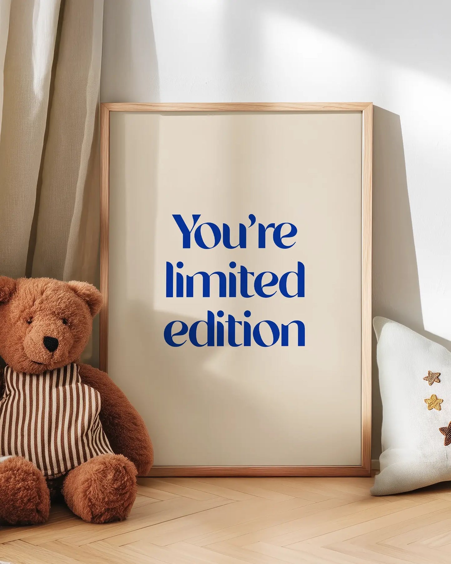 Artwork with 'You're limited edition' text next to a teddy bear on a wooden floor.