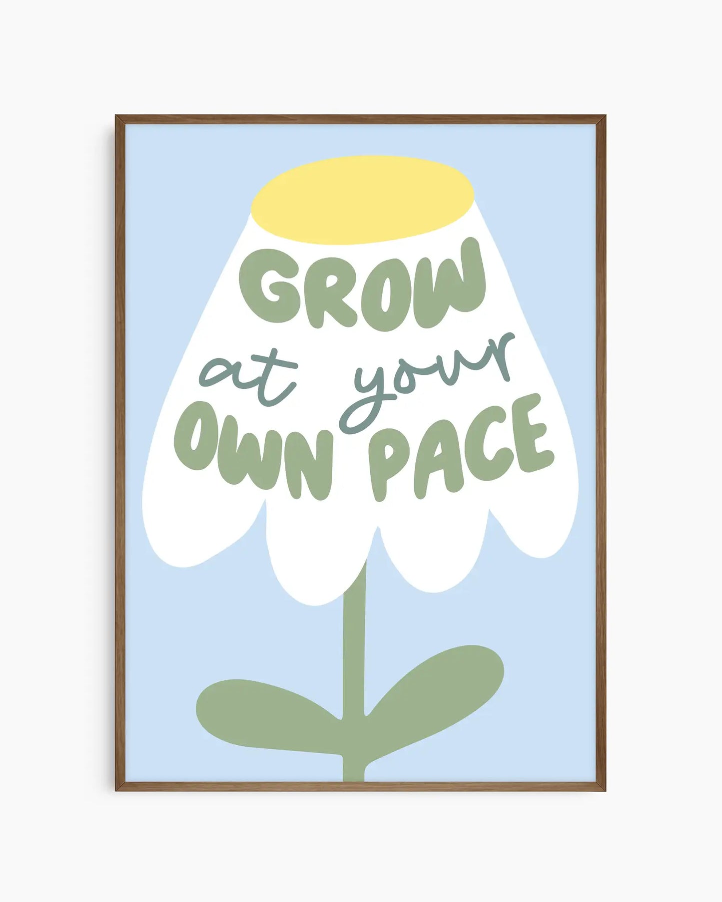Framed artwork with a flower illustration and text 'Grow at your own pace' on a light blue background.