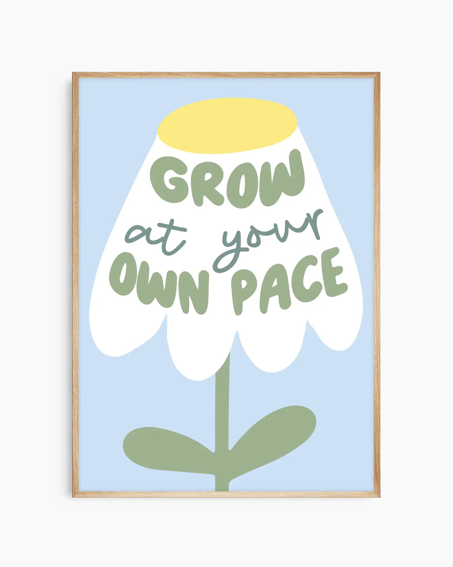 Framed artwork with a flower illustration and text 'Grow at your own pace' on a light blue background.